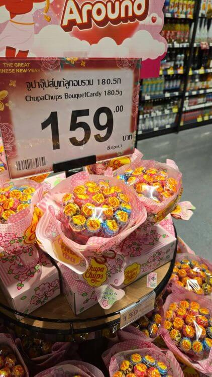 ป้ายราคา 159 บาท ช่อดอกไม้ลูกอมสุดน่ารักห่อกระดาษชมพูวางอยู่บนแร็ค