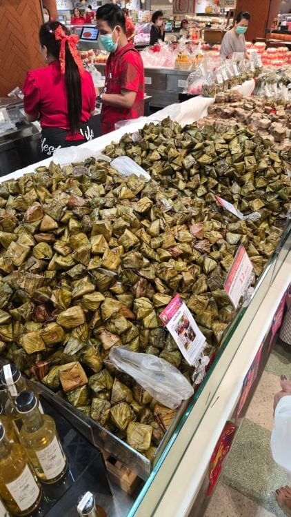 ข้าวต้มมัด ไส้หวาน ไส้เค็ม ห่อใบตองสีเขียววางเรียงสวยงามในตลาด