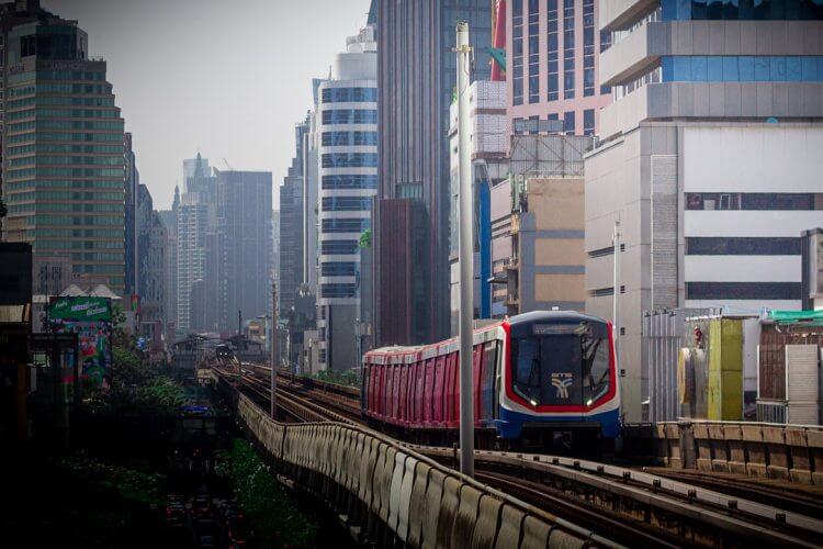 a train traveling through a city next to tall buildings