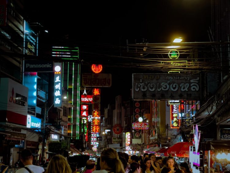 A group of people walking down a street at night