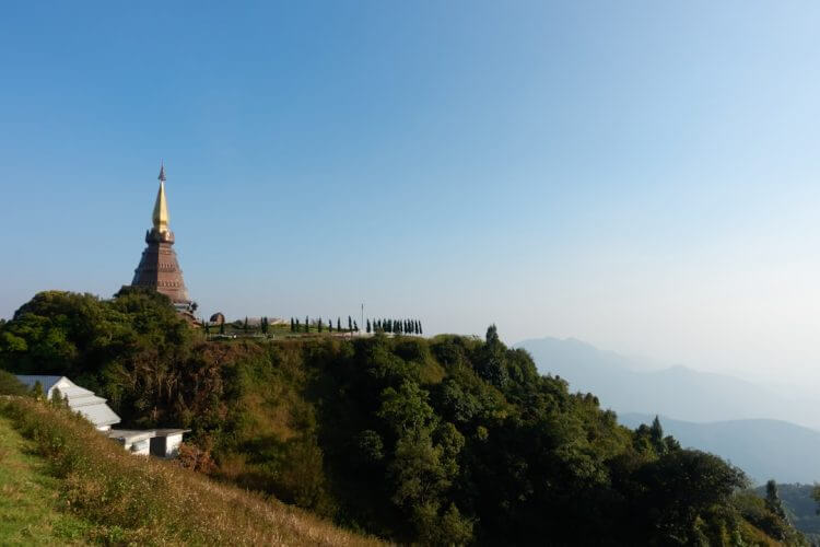 Temple on a lush green mountain under a clear sky