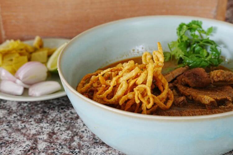 A bowl of noodles with meat and vegetables