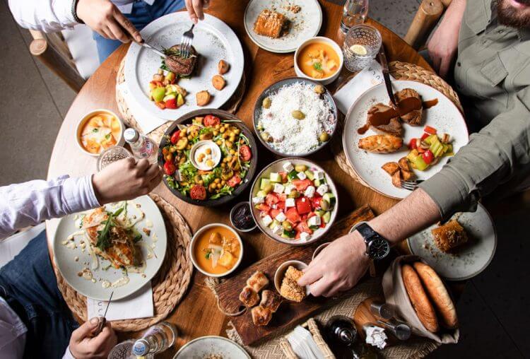 People enjoying a variety of dishes at a round table.
