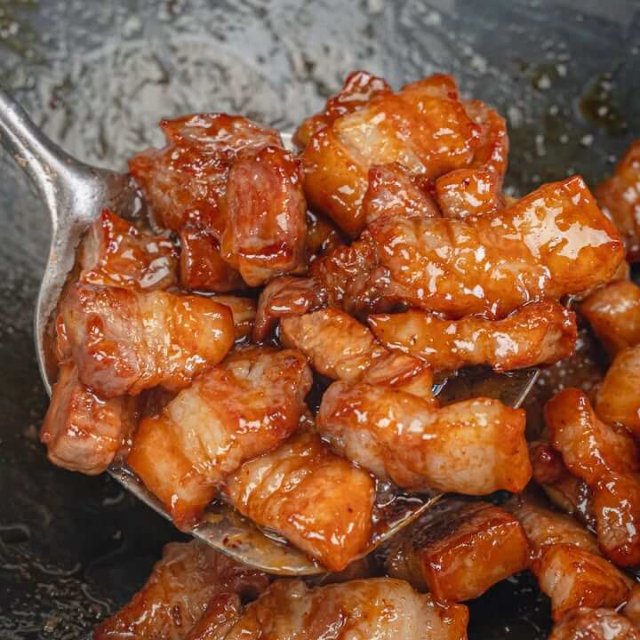 คั่วหมูสามชั้นในกระทะจนเข้ากันกับน้ำตาลปี๊บ