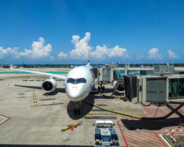 Jet plane at gate, Phuket International Airport, bright summer day.