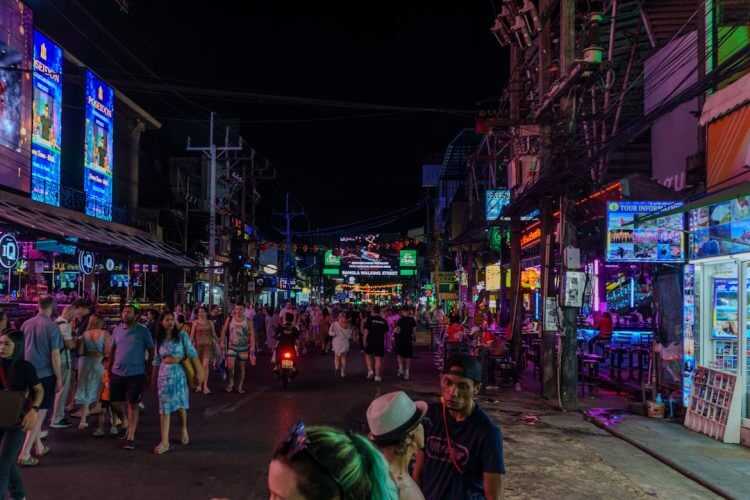 A busy street at night with neon signs.