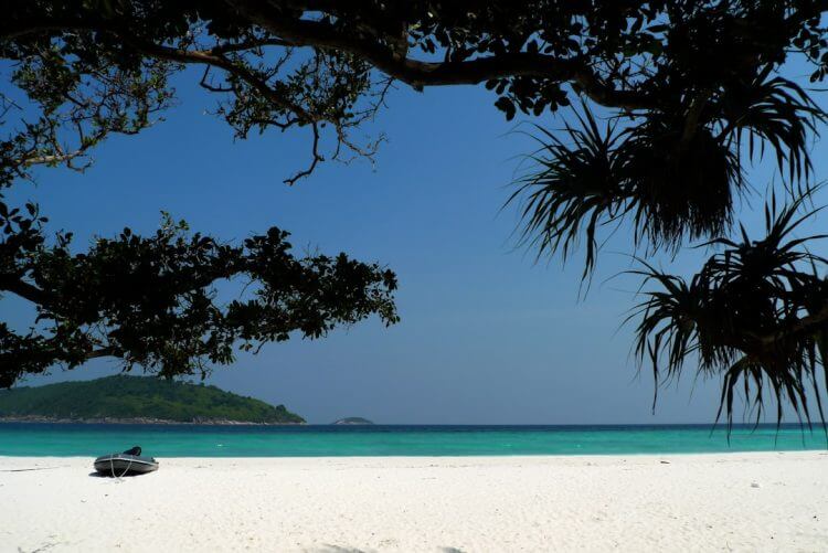 a boat sitting on top of a sandy beach