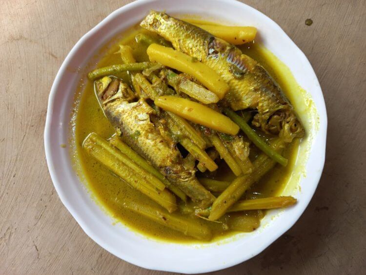 A white bowl filled with fish and green beans