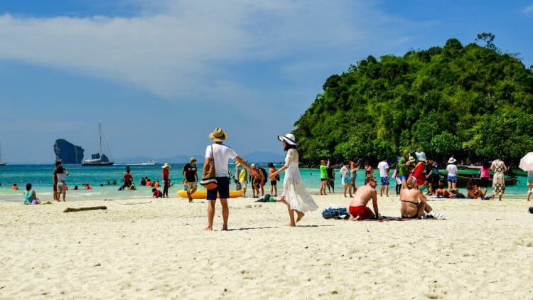 Tourists enjoying a sunny day on a tropical beach.