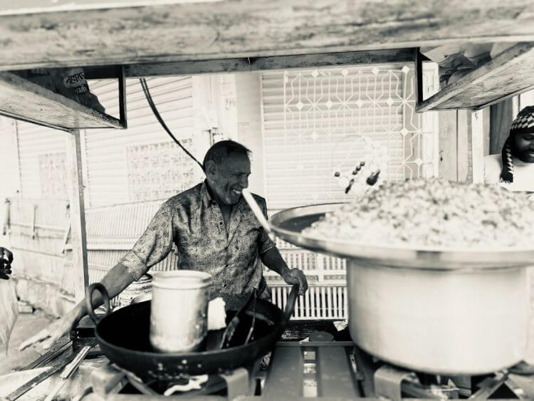 A cook is preparing food in a commercial kitchen.