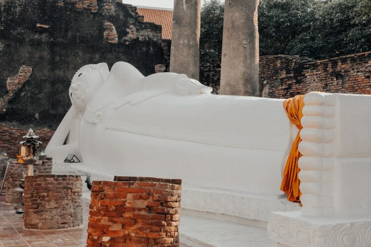 Reclining buddha statue with orange cloth draped.