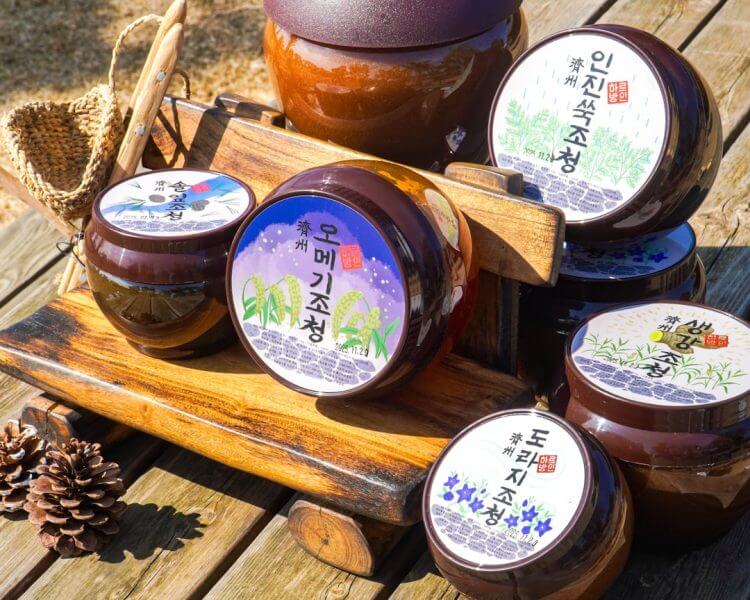 a wooden table topped with jars of honey