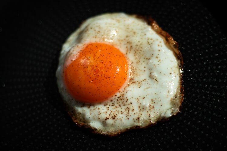A single fried egg with a bright orange yolk.