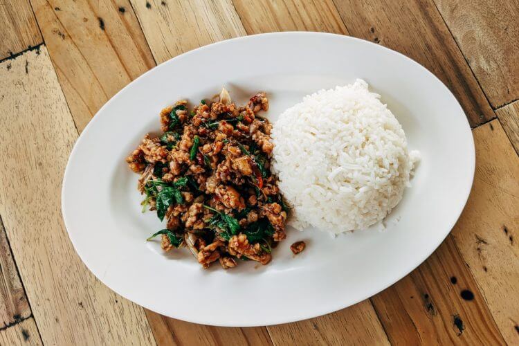 a white plate topped with rice and meat