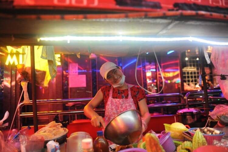 smiling woman mixing on gray bowl in foodcourt