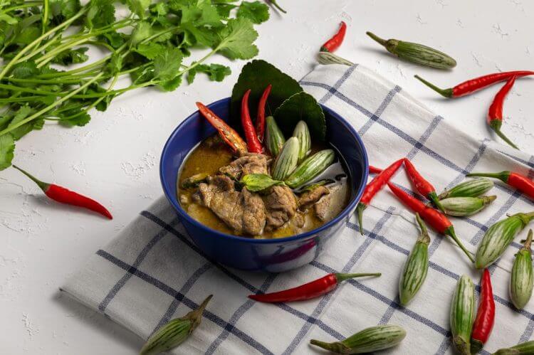 a blue bowl filled with meat and vegetables