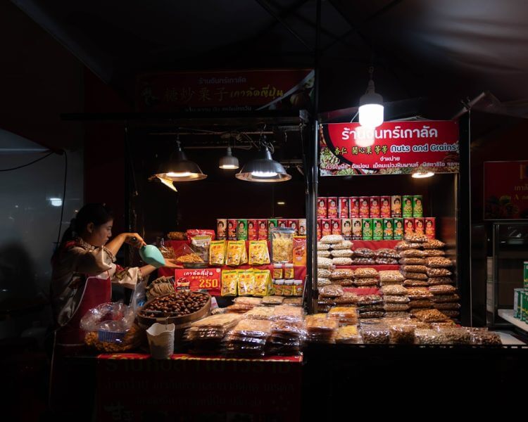 a woman standing in front of a store filled with food