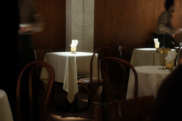 A dimly lit restaurant with tables set for dining.