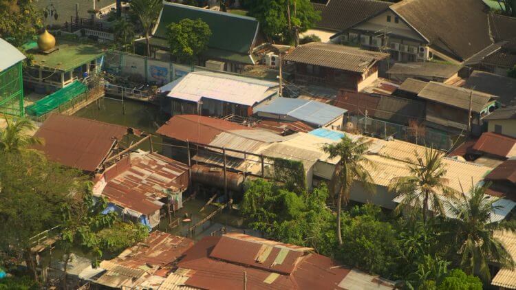 Rooftops of a village with lush greenery.