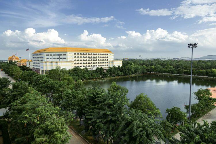 Aerial view of a large building with a pond and trees in Ayutthaya, Thailand.