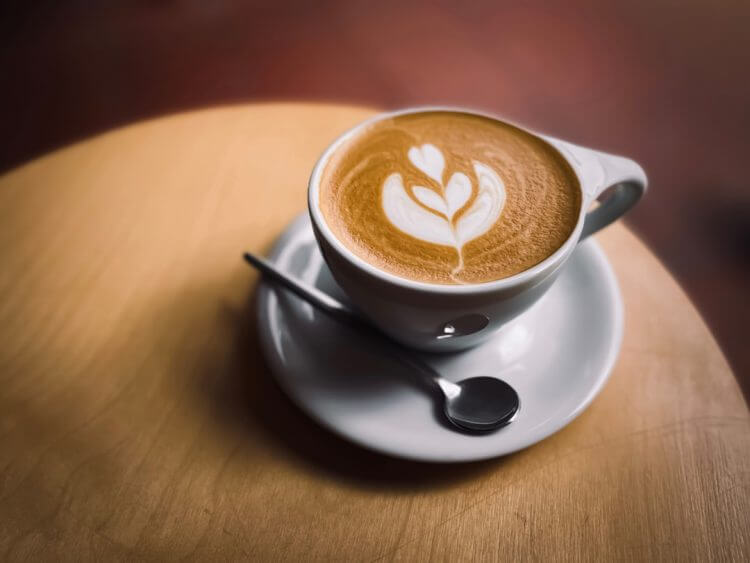 A cup of coffee with latte art on a saucer.