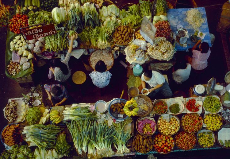 A bustling top-down view of a fresh produce market in Chiang Mai, Thailand.