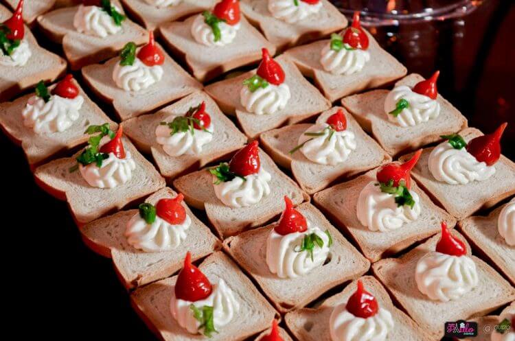Gourmet appetizers with cream cheese and red peppers on bread slices, perfect for parties or buffets.