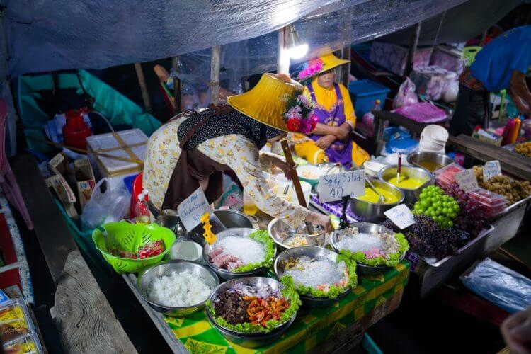 Floating market stall with colorful food and vendor