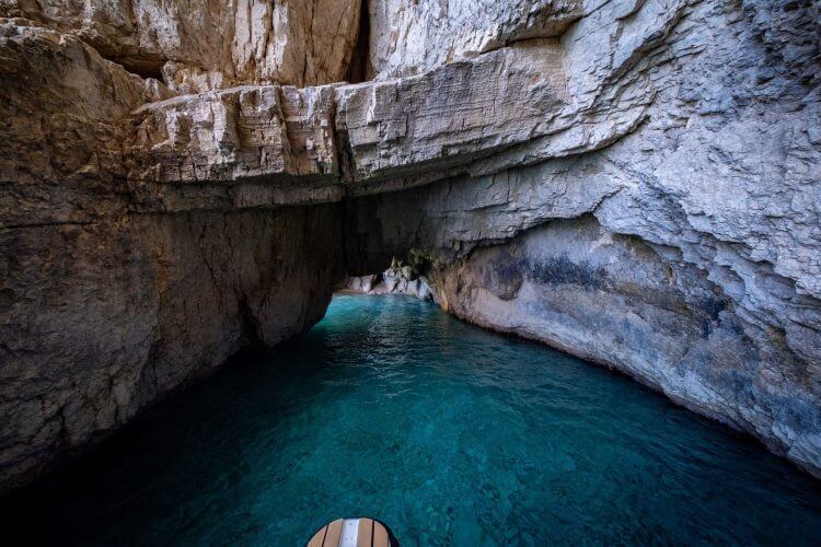 Explore a breathtaking limestone cave with vibrant blue waters, perfect for adventure seekers.