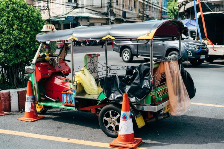 Vibrant tuk tuk parked on a busy street in Bangkok, Thailand.