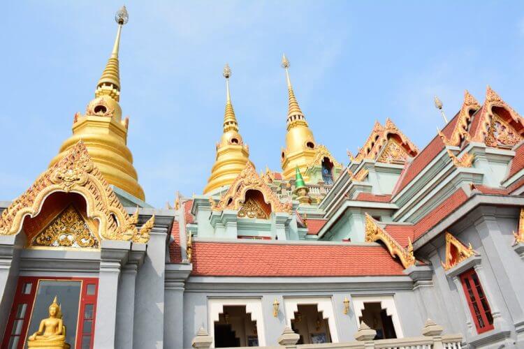 Golden spires of a buddhist temple against a blue sky