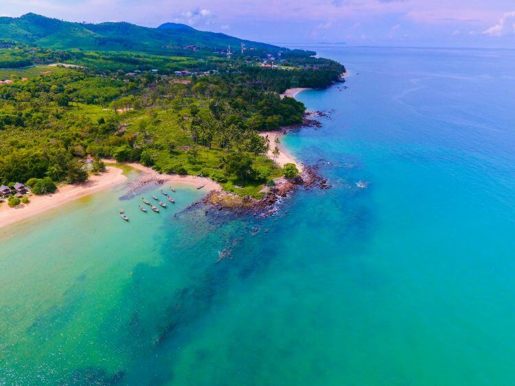 Stunning aerial view of a tropical beach and lush green landscape in Koh Lanta, Thailand.