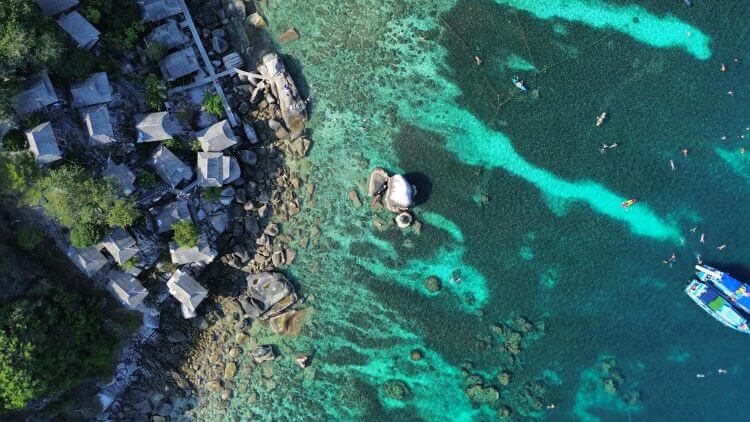Explore the stunning coastline and clear waters of Ko Tao, Thailand from above.