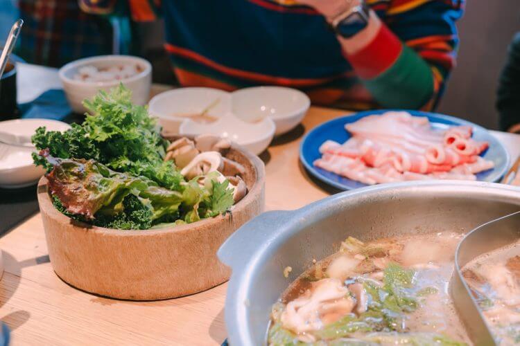 A table laden with ingredients for a hot pot meal.