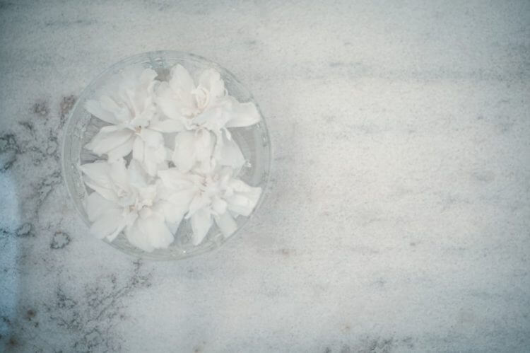 a glass bowl filled with white flowers on top of a table