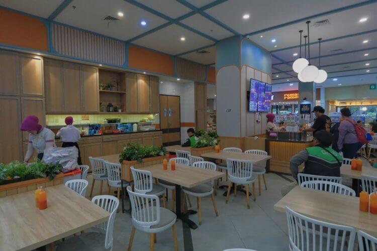 Busy modern restaurant interior with customers and staff.
