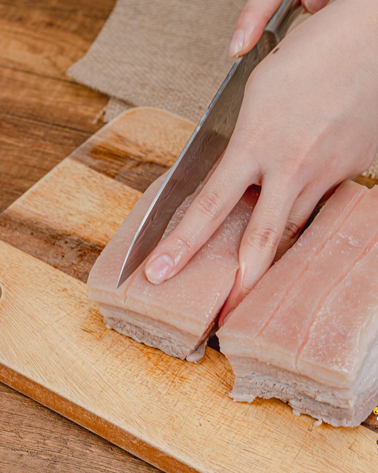 หมูกรอบหม้อทอด ขั้นที่ 5: ใช้มีดบั้งหนังเป็นแนวยาวตามชิ้นหมู ห่างกันประมาณ 1–2 เซนติเมตร…