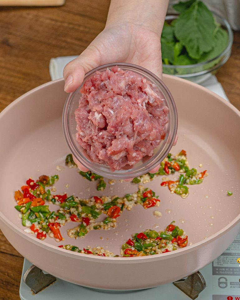 กะเพราไข่เยี่ยวม้าหมูสับ ขั้นที่ 4: ใส่หมูสับลงไป ใช้ตะหลิวยีให้หมูแตกตัว ผัดด้วยไฟแรงจนหมูเริ่มสุก