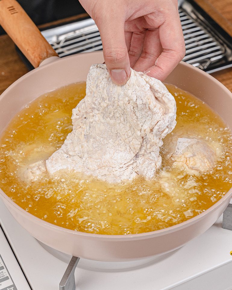 ไก่ทอดกร๊อบๆ ขั้นที่ 9: ค่อยๆ วางไก่ลงในน้ำมันทีละชิ้น โดยหย่อนออกห่างตัว ทอดทีละประมาณ 3–4 ชิ้นตามขนาดกระทะ…