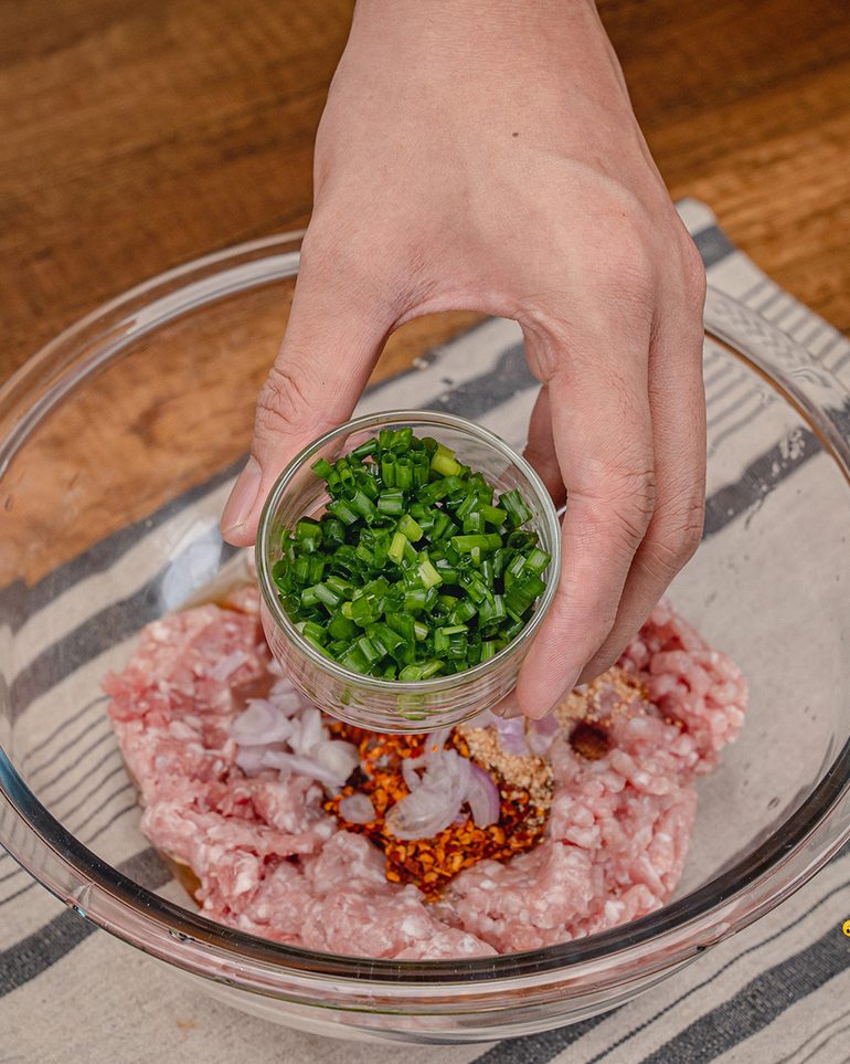 มะเขือยาวทอดกรอบสอดไส้หมูสับ ขั้นที่ 3: ใส่พริกป่น ข้าวคั่ว หอมแดงซอย และต้นหอมซอยตามลงไป