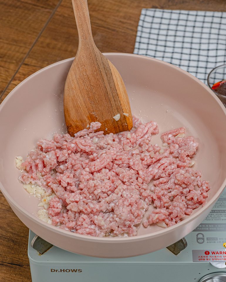 หมูสับผัดน้ำพริกเผา ขั้นที่ 3: ใส่หมูสับลงไป ใช้ตะหลิวกดยีให้หมูแตกเป็นเม็ดเล็ก รวนจนหมูเริ่มสุก…