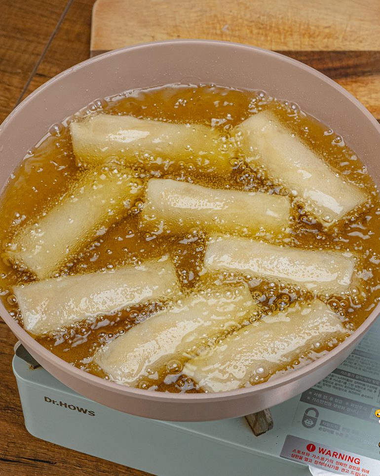 ปอเปี๊ยะปูอัดชีสเยิ้ม ขั้นที่ 6: ทอดทีละน้อยอย่าให้ชิ้นเบียดกัน พลิกเป็นระยะให้สีเสมอกัน ทอดประมาณ 3–5…