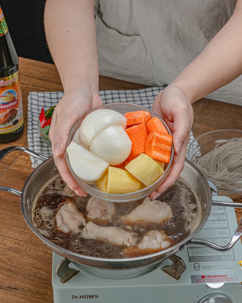 จิมดักไก่ตุ๋นซอสดำ ขั้นที่ 6: ใส่แครอท มันฝรั่ง และหอมใหญ่ลงไป กดผักให้จมน้ำซอส