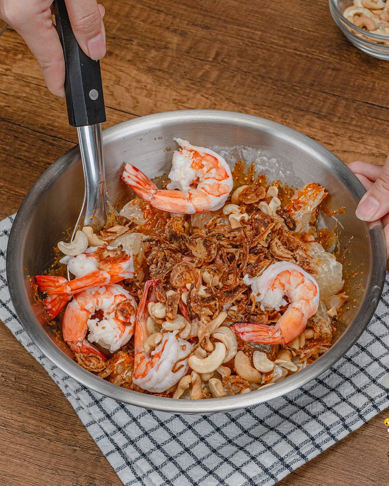 ยำข้าวคั่วส้มโอ ขั้นที่ 6: ใส่กุ้งลวก ตามด้วยเม็ดมะม่วงหิมพานต์และหอมเจียว คลุกเคล้าเบาๆ ให้เข้ากันดี
