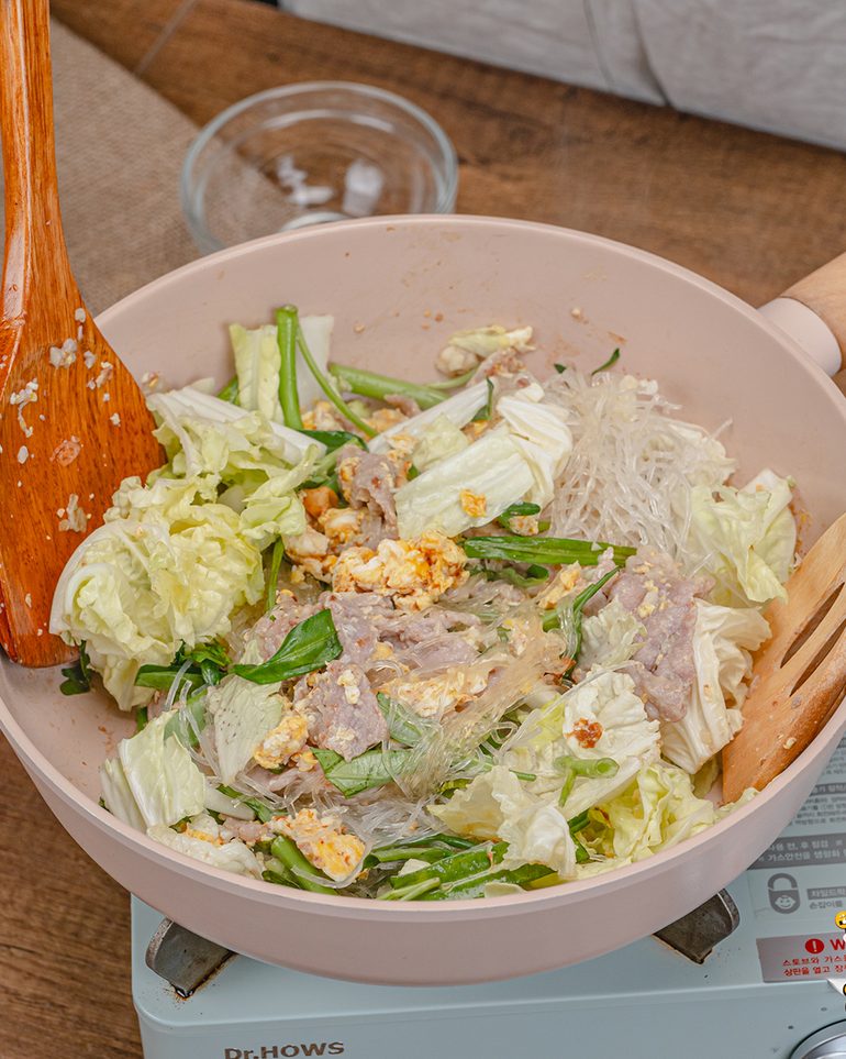 สุกี้แห้งหมูหมักน้ำมันงา ขั้นที่ 6: ใส่ผัก ผัดคลุกกับเส้นจนผักเริ่มสุกและสลดลงเล็กน้อย แต่ยังกรอบอยู่