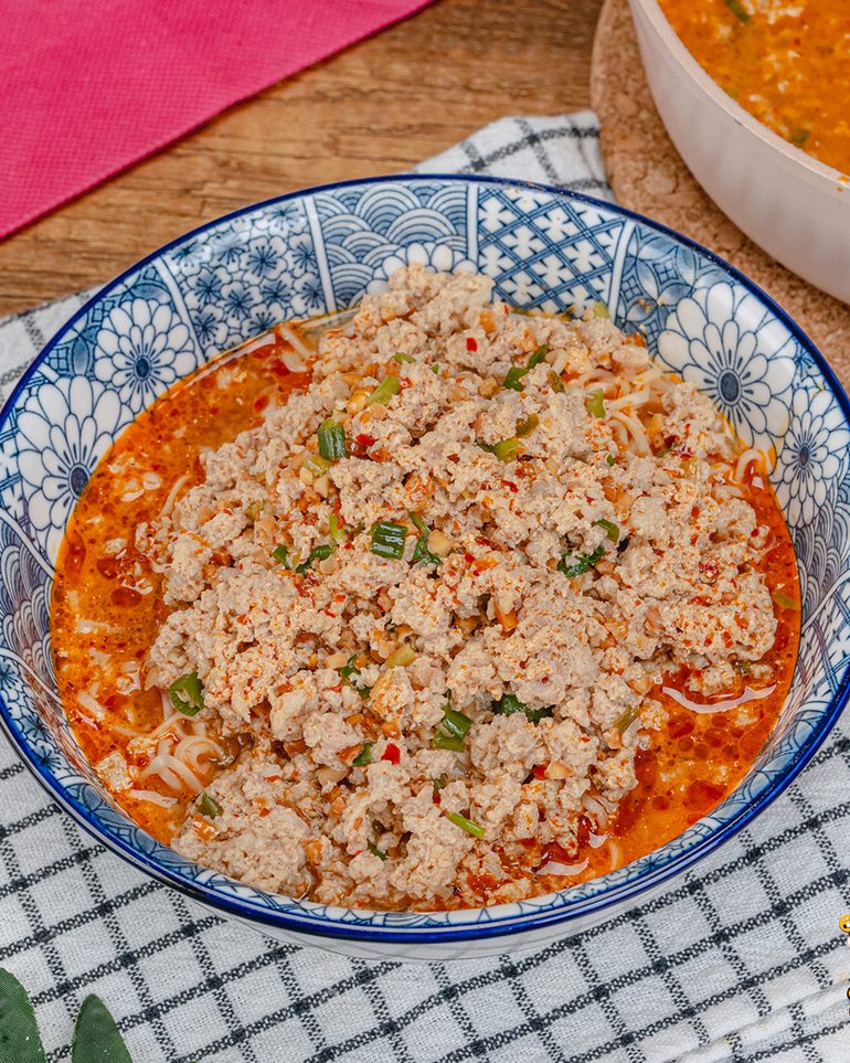 มาม่าต้มยำหมูสับ ขั้นที่ 12: ตักน้ำซุปหมูสับราดลงบนเส้นบะหมี่ที่ลวกเตรียมไว้ ตักหมูขึ้นพูนหน้าชาม เสิร์ฟทันที