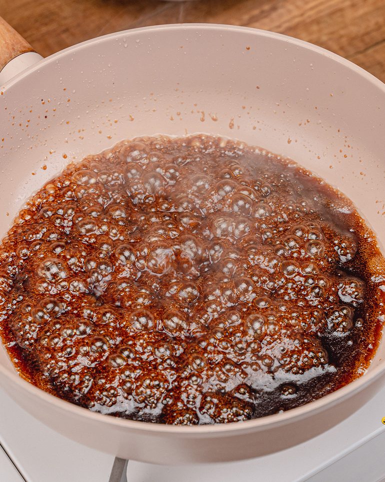 หมูทอดชาววัง ขั้นที่ 8: เติมน้ำเปล่าเล็กน้อยให้ซอสคลายตัวพอจะคลุกหมูได้ทั่ว ไม่ต้องเติมจนซอสใส